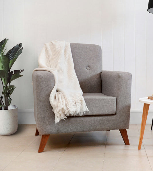 Soft cream throw blanket draped over a comfortable armchair